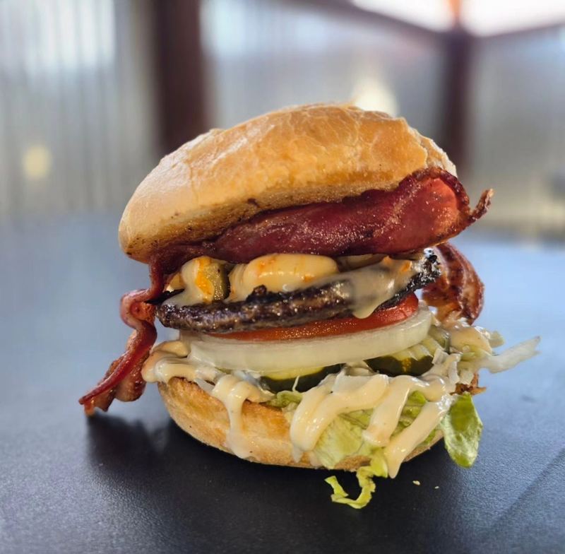 Bacon cheeseburger with lettuce, tomato, and pickles
